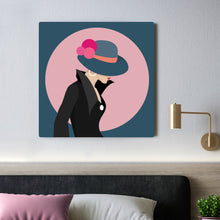 Load image into Gallery viewer, Cool Cats 6 - A glimse of earrings under a pompom hat - dark bluegrey hat - rose pompoms - black jacket - pink circle - dark bluegrey background
